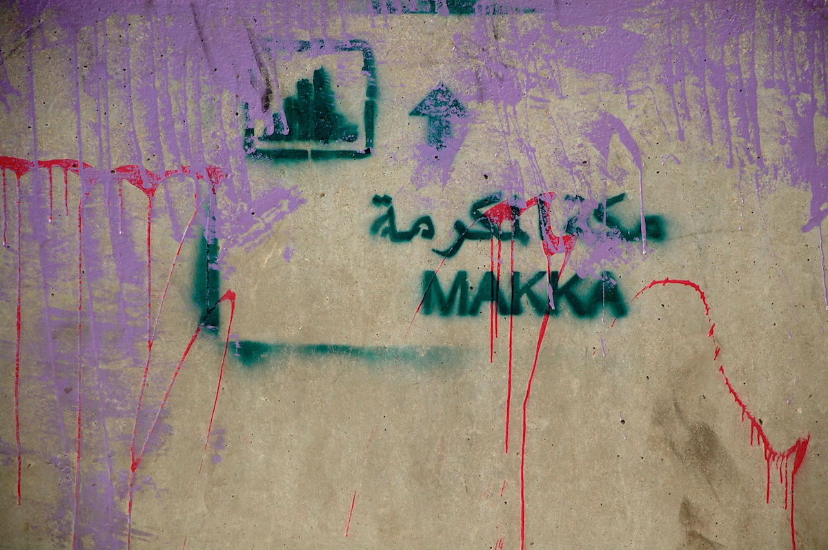"Makka" with a skyline: a commentary on the construction around the holy site of the Ka'ba in Mecca, stenciled in al-Balad in Jeddah by Sarah al-Abdali.